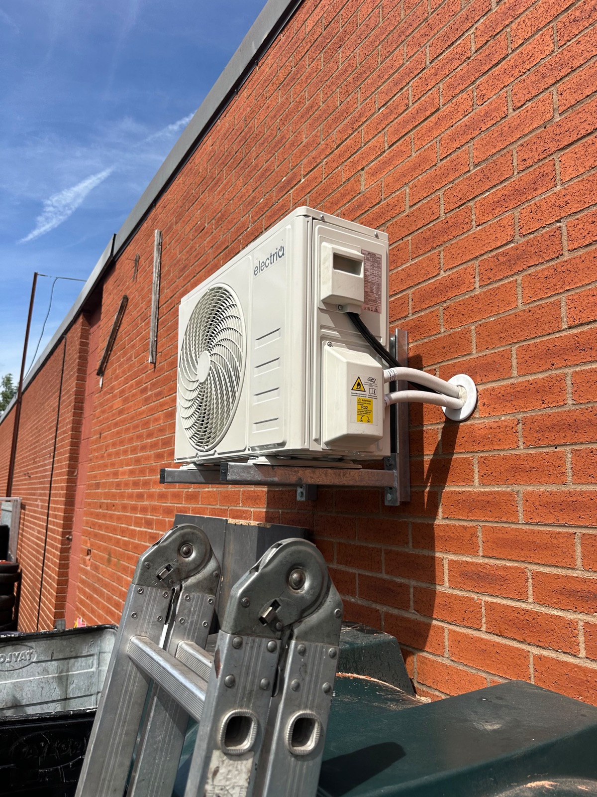 Bracket-mounted outdoor unit with tidy pipe covers